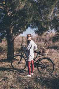 Full length portrait of man standing on bicycle