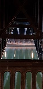 Reflection of bridge in swimming pool at night