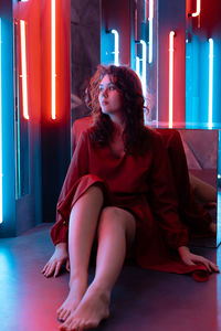Young woman sitting on floor at home
