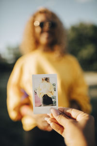 Midsection of woman holding camera