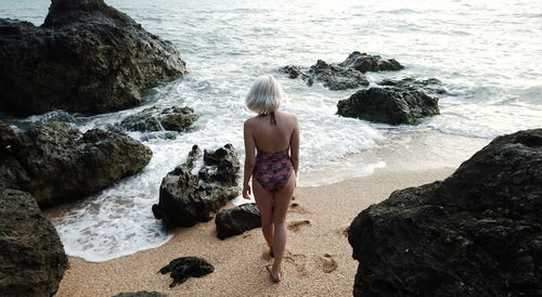 Rear view of woman standing on beach