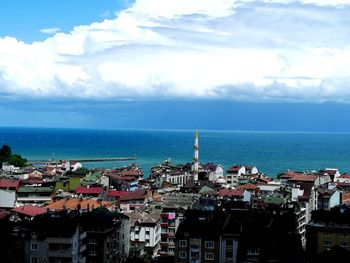 High angle view of townscape by sea against sky