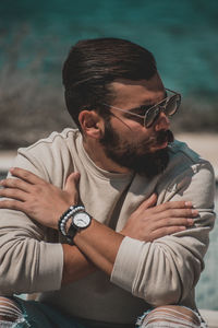 Young man wearing sunglasses sitting outdoors