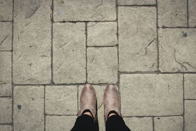 Low section of man standing on tiled floor