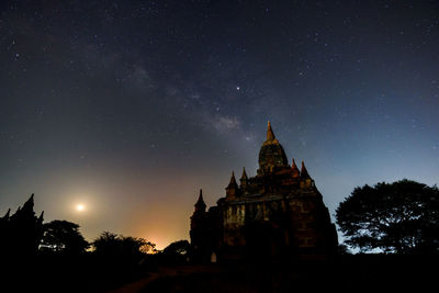 Low angle view of silhouette building against sky at night
