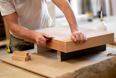 Midsection of carpenter working on table