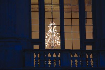 Low angle view of illuminated glass window in building