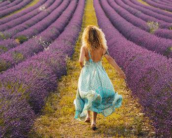 Full length rear view of woman standing on field