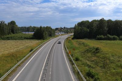 Road amidst trees against sky