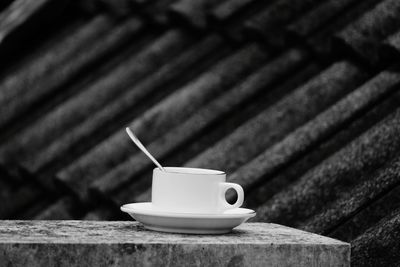 Close-up of coffee cup on retaining wall