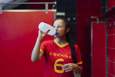 Young player drinking water in locker room
