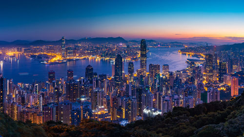 Illuminated cityscape against sky at night