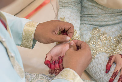 Midsection of couple holding hands