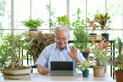 Young man using mobile phone while sitting on table