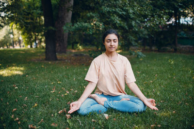 Young woman meditating at park