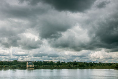 Scenic view of lake against cloudy sky