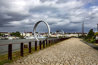 Ferris wheel by river against sky