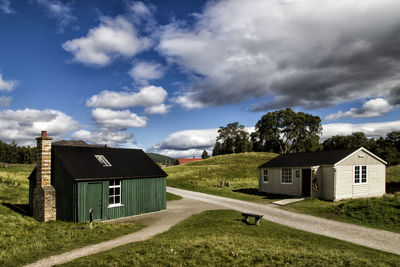 Houses by trees against sky