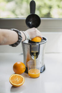 Midsection of man preparing orange juice