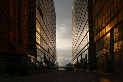 Taxi driving in between two office buildings during the sunset