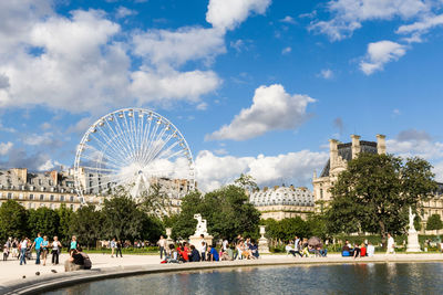 View of people at lakeside in park during sunny day