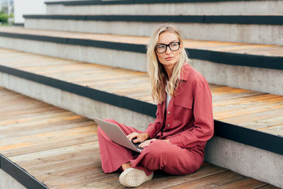 Portrait of young woman sitting on steps