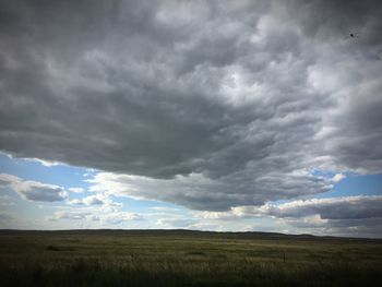 Scenic view of field against cloudy sky