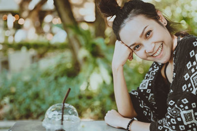 Outdoor portrait of beautiful happy young woman smiling broadly with toothy smile