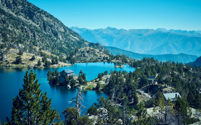 High angle view of lake and mountains against blue sky