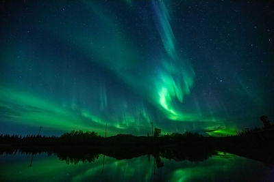 Scenic view of lake against sky at night