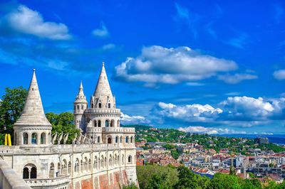 Buildings in city against blue sky