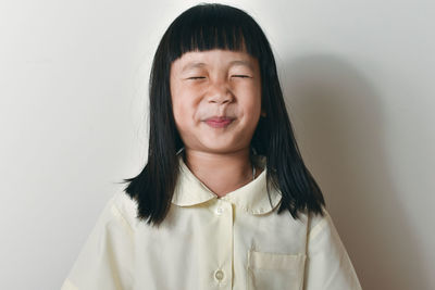 Portrait of smiling woman against wall