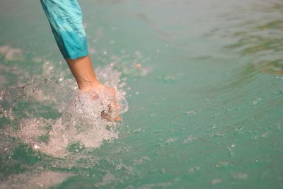 Low section of boy standing in sea