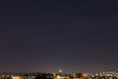 Illuminated buildings against sky at night