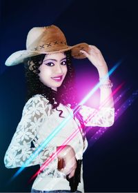 Portrait of smiling young woman against black background