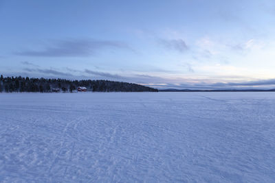 Scenic view of snow covered field against sky