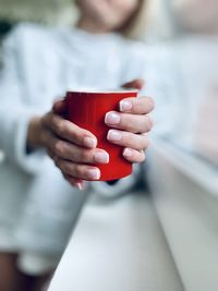 Midsection of man holding coffee cup