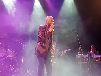 Panoramic view of man holding umbrella at music concert