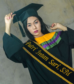 Portrait of woman standing against wall