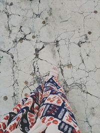 Low section of woman standing on cracked concrete flooring