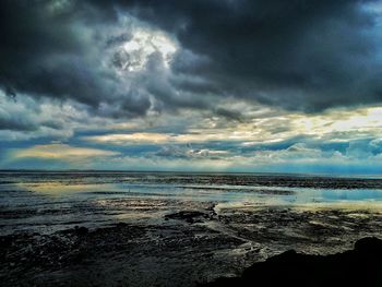 Scenic view of sea against storm clouds