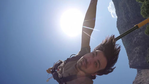 Low angle view of woman against sky on sunny day