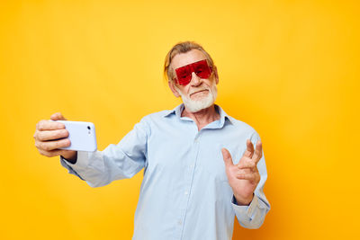 Senior man gesturing while taking selfie