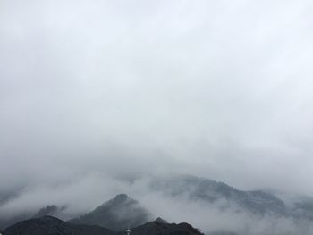 Scenic view of mountains against cloudy sky