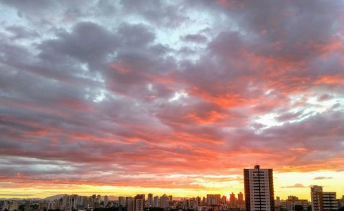 View of cityscape against cloudy sky during sunset
