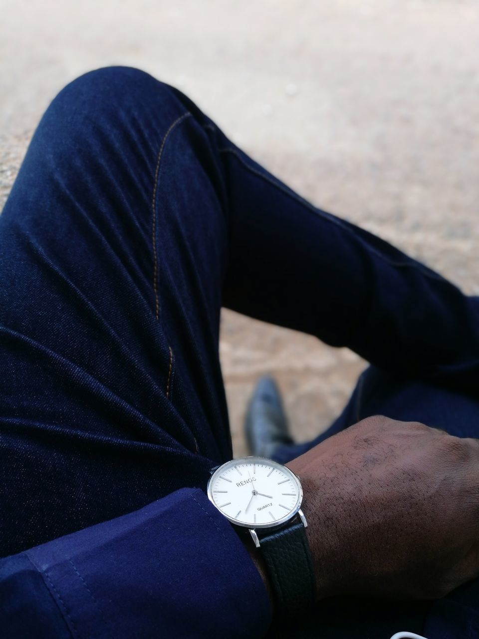 real people, one person, lifestyles, wristwatch, hand, watch, human hand, human body part, time, leisure activity, men, personal perspective, body part, focus on foreground, day, adult, low section, casual clothing, human leg, outdoors, clock, jeans, checking the time