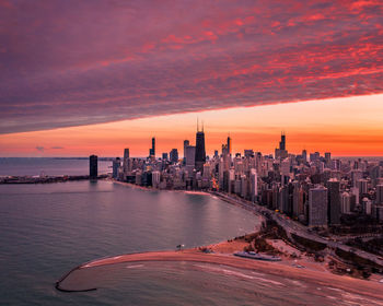 Modern buildings in city against sky during sunset