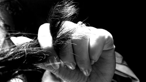 Woman with hands hair against black background