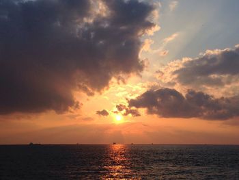 Scenic view of sea against cloudy sky during sunset