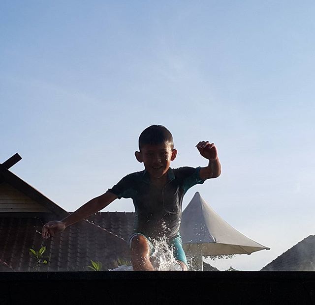 LOW ANGLE VIEW OF YOUNG WOMAN STANDING ON RAILING